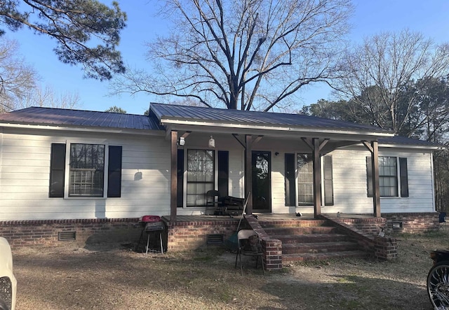 view of front of property featuring a porch, crawl space, and metal roof