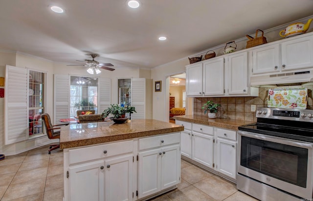 kitchen featuring electric stove, tile countertops, under cabinet range hood, backsplash, and light tile patterned flooring