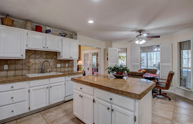 kitchen featuring light tile patterned flooring, a sink, backsplash, tile counters, and dishwasher