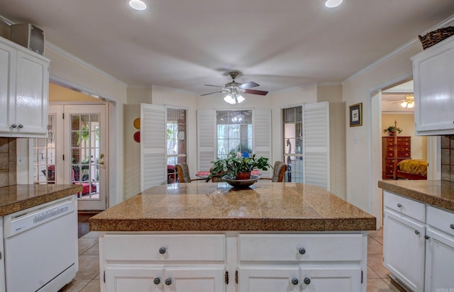 kitchen with tile countertops, light tile patterned floors, crown molding, and dishwasher