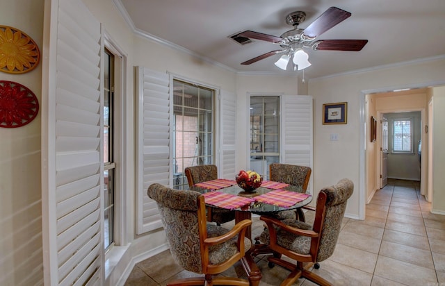 dining space featuring light tile patterned floors, baseboards, and crown molding