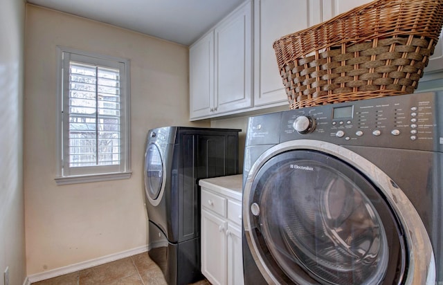 laundry room with cabinet space, light tile patterned floors, baseboards, and independent washer and dryer