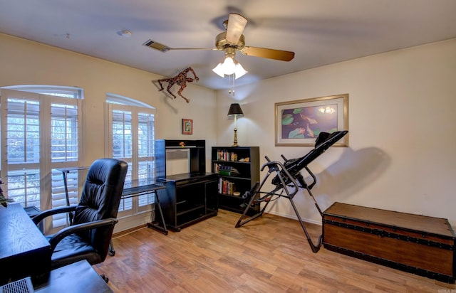 office space with baseboards, visible vents, a ceiling fan, and light wood-style floors