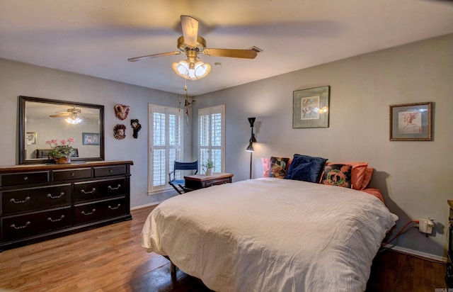 bedroom with light wood-type flooring, a ceiling fan, and baseboards