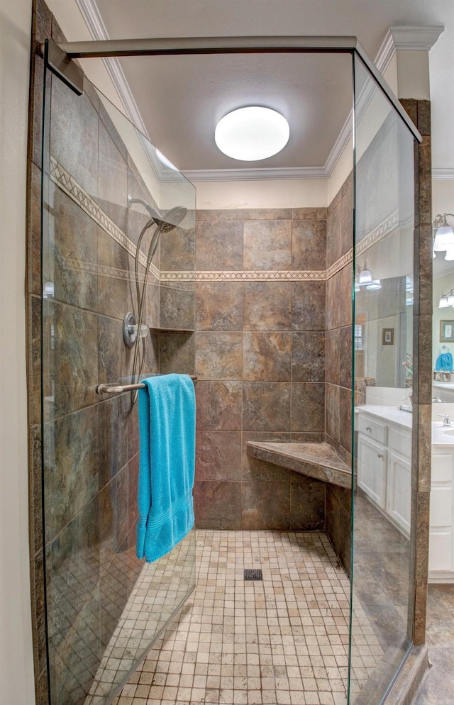 bathroom with ornamental molding, tiled shower, and vanity