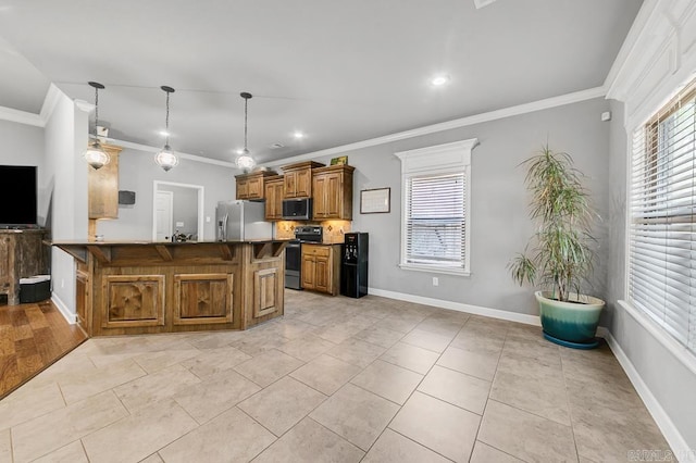 kitchen with stainless steel appliances, a kitchen breakfast bar, brown cabinetry, dark countertops, and crown molding