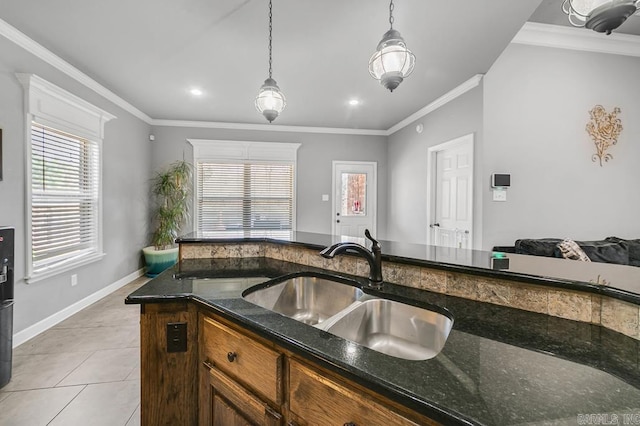 kitchen with decorative light fixtures, a sink, dark stone countertops, and light tile patterned floors