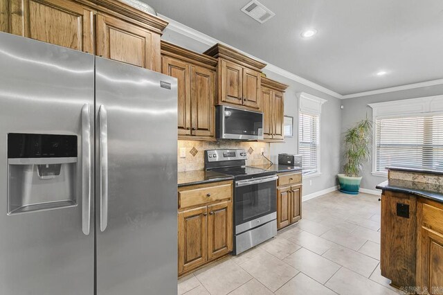 kitchen with stainless steel appliances, visible vents, ornamental molding, and backsplash