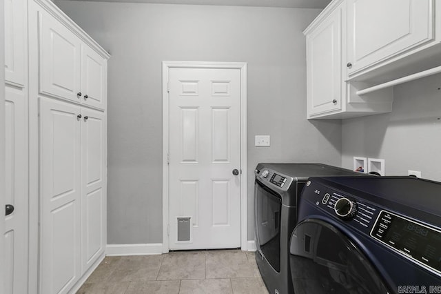 laundry room featuring light tile patterned floors, cabinet space, baseboards, and separate washer and dryer