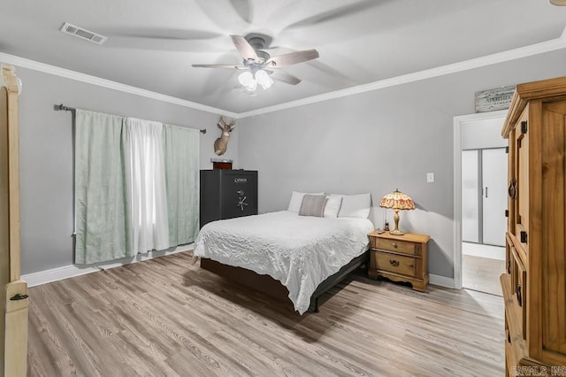 bedroom featuring ornamental molding, light wood-type flooring, and visible vents