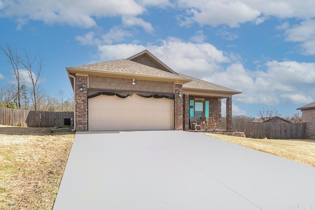 view of front of property with a garage, driveway, fence, and brick siding