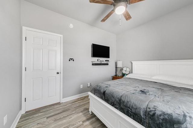 bedroom with ceiling fan, baseboards, and wood finished floors