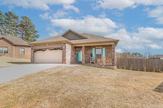view of front of house with a garage, driveway, brick siding, fence, and a front yard