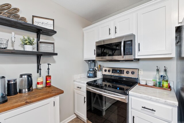 kitchen featuring stainless steel appliances, light tile patterned flooring, white cabinetry, and open shelves