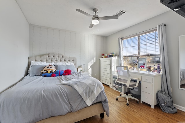 bedroom featuring ceiling fan, visible vents, and light wood-style flooring