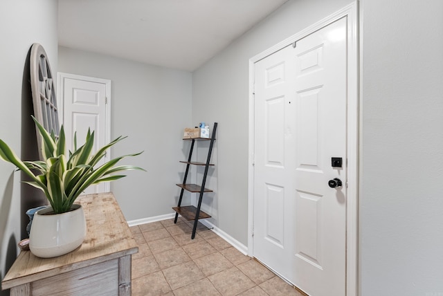 foyer featuring light tile patterned floors and baseboards