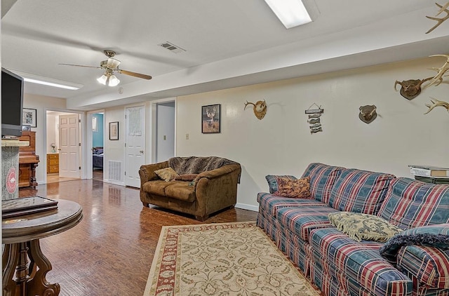 living room featuring baseboards, wood finished floors, visible vents, and a ceiling fan