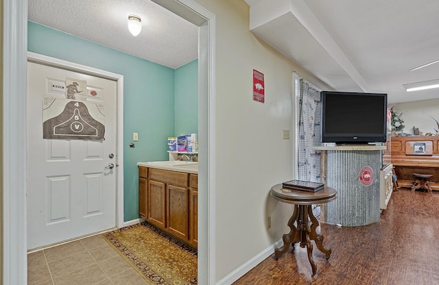 interior space featuring a sink, baseboards, and a textured ceiling