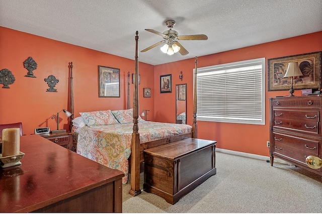 bedroom featuring a ceiling fan, light carpet, a textured ceiling, and baseboards