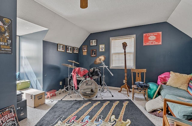 playroom featuring carpet, baseboards, vaulted ceiling, and a textured ceiling