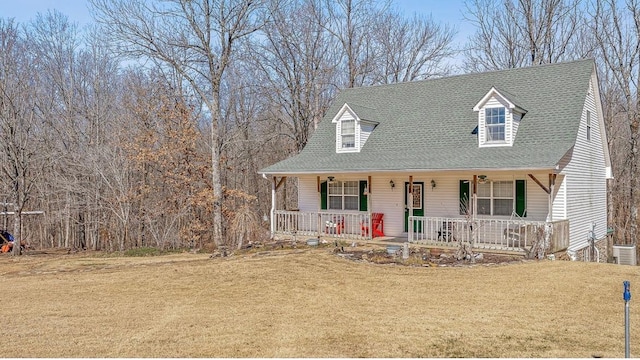 cape cod-style house with covered porch, central AC unit, roof with shingles, and a front yard