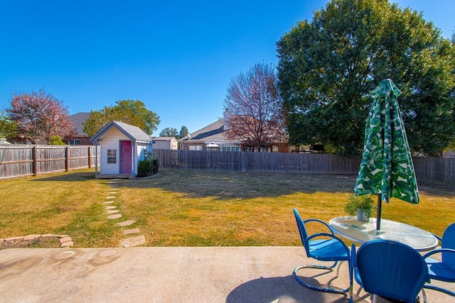 view of yard featuring outdoor dining area, a patio, a shed, a fenced backyard, and an outdoor structure