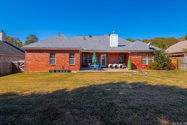 back of property with a patio area, a fenced backyard, brick siding, and a chimney