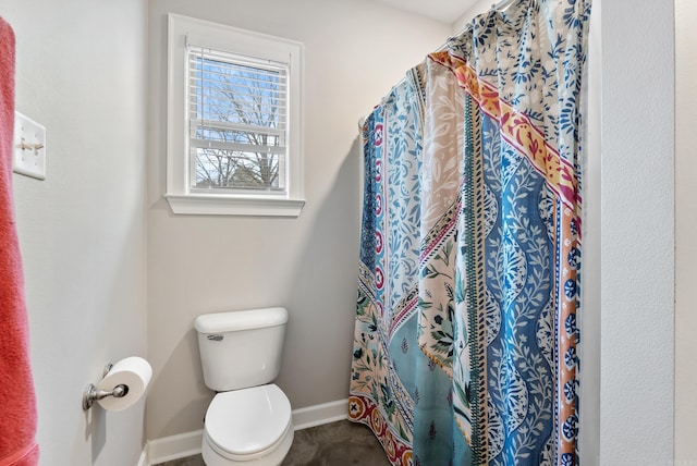 full bathroom featuring toilet, curtained shower, and baseboards