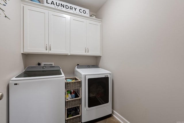 laundry room with cabinet space, washing machine and dryer, and baseboards