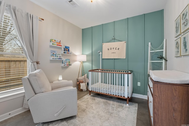 bedroom featuring a crib, visible vents, and baseboards