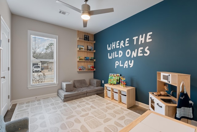 rec room with a sink, ceiling fan, visible vents, and baseboards