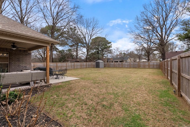 view of yard with a patio, a ceiling fan, a shed, a fenced backyard, and an outdoor structure