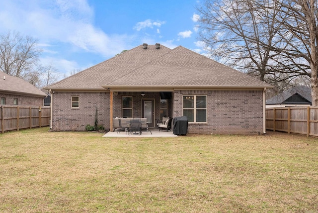 back of house featuring a yard, a fenced backyard, brick siding, and a patio