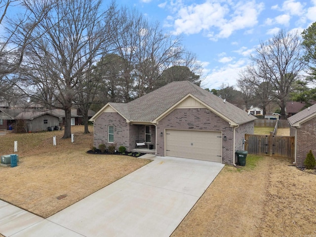 ranch-style home with an attached garage, brick siding, fence, concrete driveway, and roof with shingles