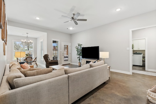 living room with recessed lighting, washer / clothes dryer, concrete flooring, baseboards, and ceiling fan with notable chandelier