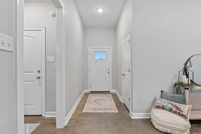 entrance foyer with baseboards and concrete flooring