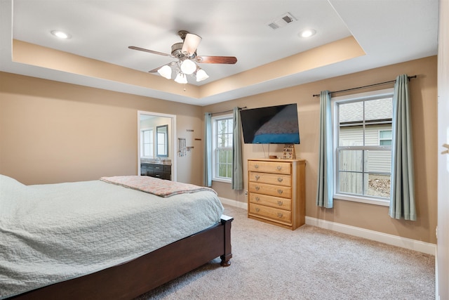 bedroom with light carpet, a raised ceiling, visible vents, and baseboards