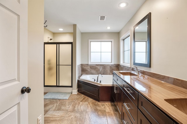 bathroom with a garden tub, a sink, visible vents, a shower stall, and double vanity