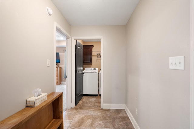 corridor with independent washer and dryer and baseboards