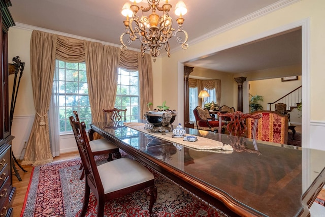 dining area featuring ornamental molding, stairway, wood finished floors, and a notable chandelier