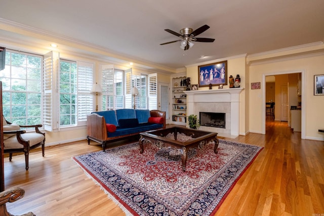 living room with ornamental molding, a fireplace, wood finished floors, and baseboards