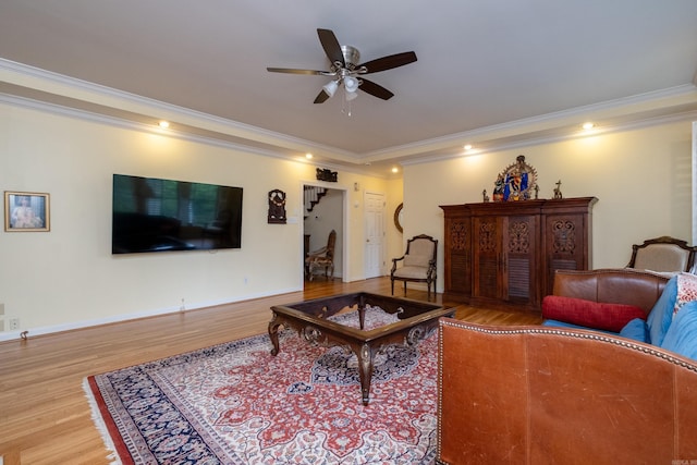 living area with ornamental molding, ceiling fan, and wood finished floors