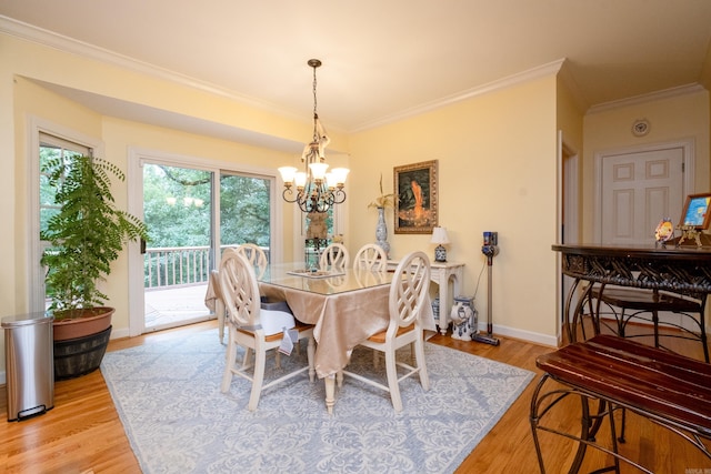 dining room with light wood finished floors, baseboards, a chandelier, and ornamental molding