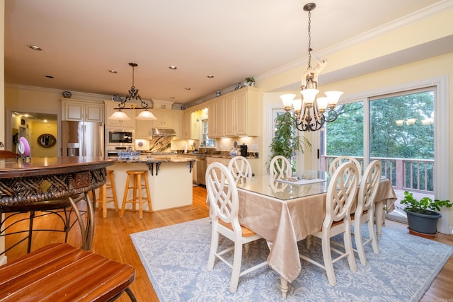 dining area with light wood-style floors, recessed lighting, a chandelier, and ornamental molding