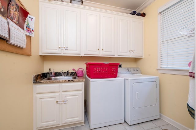 clothes washing area featuring light tile patterned flooring, a sink, baseboards, cabinet space, and washing machine and clothes dryer