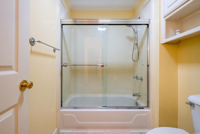 bathroom with combined bath / shower with glass door, crown molding, and toilet