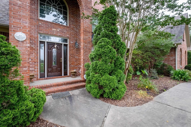 view of exterior entry featuring brick siding