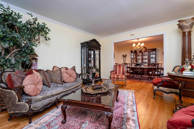 living room with crown molding, a notable chandelier, and wood finished floors