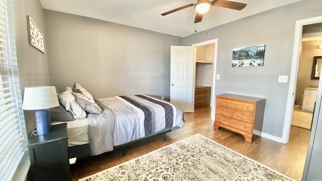 bedroom with wood finished floors, a ceiling fan, and baseboards