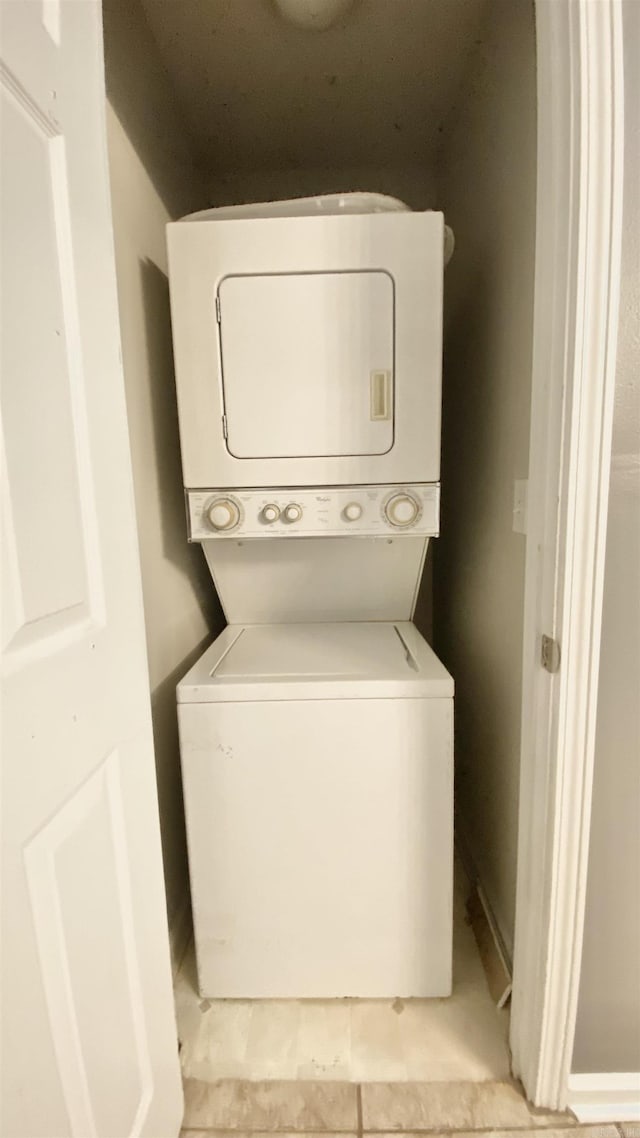 laundry area featuring stacked washer / drying machine and laundry area